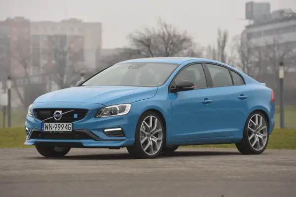 Błękitne Volvo S60 na tle budynków. Poznaj jego wymiary i możliwości.