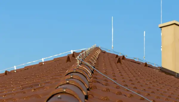 Nowy dach z brązowej dachówki, zabezpieczony nowoczesną instalacją odgromową.