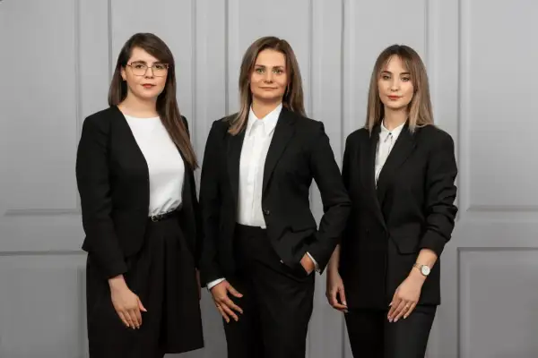 Trzy kobiety w czarnych garniturach. Zastanawiasz się, ile bierze adwokat za reprezentowanie w sądzie?