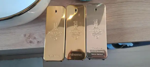 Trzy flakoniki perfum Paco Rabanne 1 Million 100ml w złotych i srebrnych odcieniach.