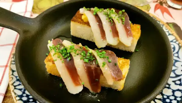 Deliciosos pinchos de jamón y pan tostado, perfectos para disfrutar en restaurantes con zona infantil en la Sierra de Madrid.