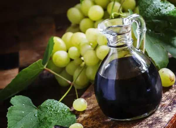 Ciemny płyn w karafce i winogrona. Szukasz, czym zastąpić ocet balsamiczny? Oto inspiracja.