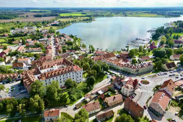 Idealne miejsce, gdzie na Mazury we dwoje: urokliwe miasteczko z zamkiem, jezioro z przystanią i zielone pola.
