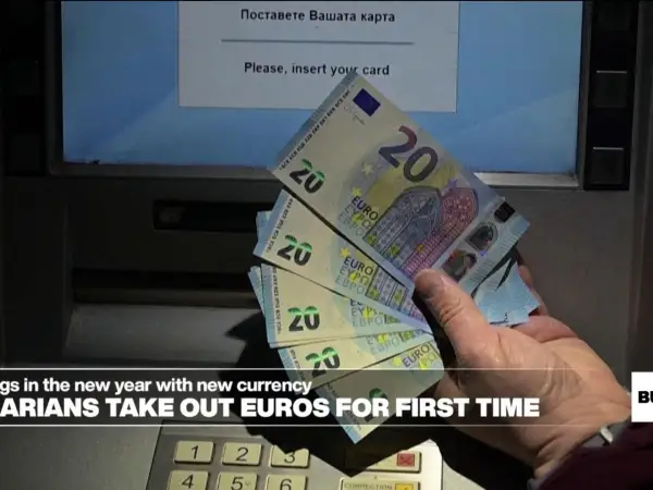 Ręka trzyma banknoty 20 euro przy bankomacie. Bułgarzy po raz pierwszy wypłacają nową walutę.