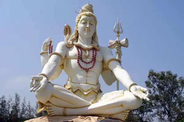 Stor staty av Shiva, en viktig gudom inom hinduismen, sitter i meditation med en orm runt halsen och en treudd i handen.