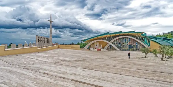 Piazza del Santuario di San Pio, il paese di Padre Pio, con la sua architettura moderna e il cielo drammatico.