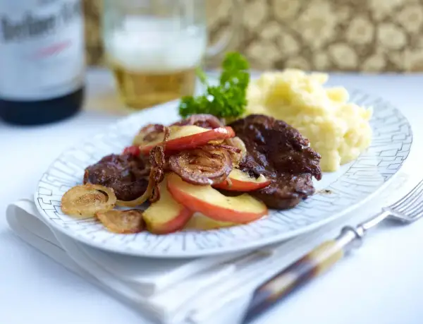 Herzhaft gebratene leber mit zwiebeln und apfel, dazu Kartoffelpüree und ein Bier.