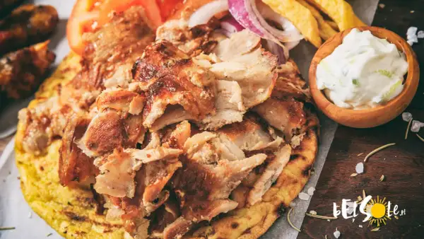 Pyszne jedzenie w Grecji: gyros z kurczaka na chlebku pita, z pomidorami, cebulą, frytkami i sosem tzatziki.