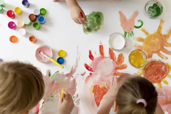 Niños pequeños creando arte con pinturas de colores. Soles, flores y mucha imaginación en esta actividad de arte para niños de 3 a 5 años.