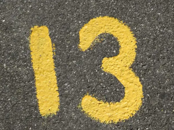 Żółta liczba 13 namalowana na asfalcie.
