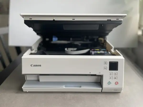 Drukarka Canon TS6351 z otwartą klapą, gotowa do drukowania. Dowiedz się, jak połączyć drukarkę Canon z telefonem, by drukować bezprzewodowo.