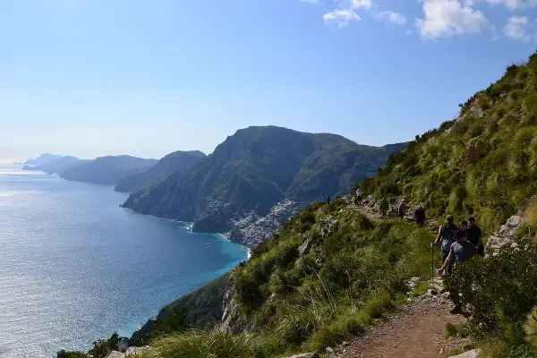 Escursionisti sul Sentiero degli Dei, con vista mozzafiato sulla costa amalfitana e il mare blu intenso.