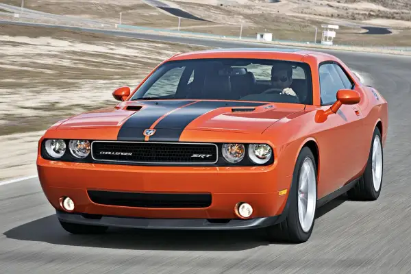 Pomarańczowy Dodge Challenger SRT na torze wyścigowym. Poznaj jego dodge challenger dane techniczne i poczuj moc!