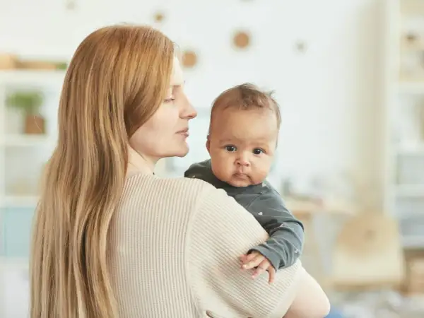 Mama tuli 4 miesięczne dziecko odchyla głowę do tyłu, patrząc z zaciekawieniem.