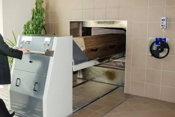 Wózek z trumną wjeżdża do pieca kremacyjnego. Proces ten nie powoduje bólu, jest to ostatnie pożegnanie.