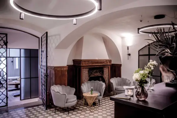 Eleganckie fotele SPA, kominek i bukiet kwiatów w przytulnym wnętrzu.