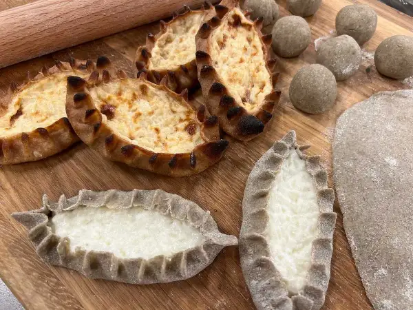 Piroger recept: Nybakade piroger med krämig fyllning och degbollar redo för ugnen.