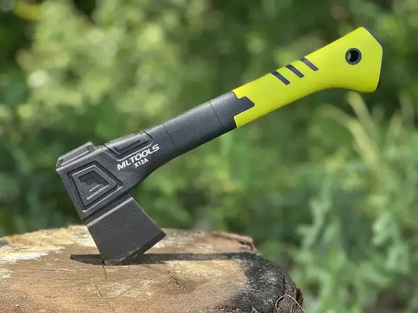 Una pala hacha moderna, con mango verde brillante y negro, lista para la acción en un tocón de madera.