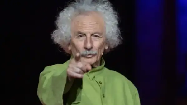 El brujo del Teatro de las Esquinas, con su melena blanca y camisa verde, señala al público.