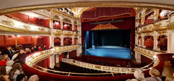 Prunkvoller Zuschauerraum im Oper Breslau, mit Logen, rotem Samt und goldener Verzierung.