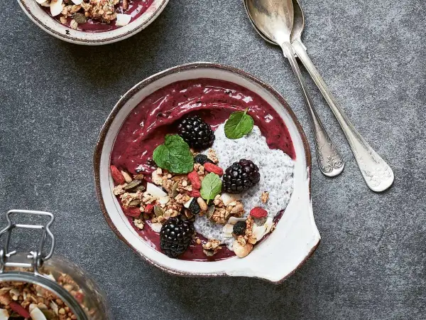 En läcker smoothie bowl med bär, granola, chiafrön och mynta. Perfekt för en hälsosam frukost eller mellanmål.