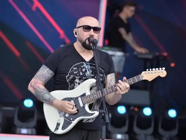 Ogonyk gra na białej gitarze, w tle klawiszowiec. To może być początek koncertu, gdzie kombi piosenki alfabetycznie.