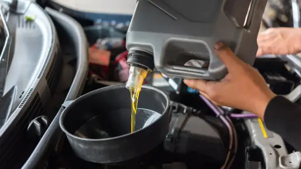 Persona vierte aceite de motor en un embudo. ¿Se puede mezclar aceite 5w30 y 5w40?