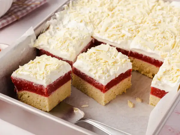 Schichtkuchen mit roter Fruchtschicht, weißer Creme und Schokostreuseln, wie von Frau Holle gebacken.