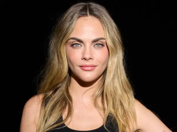 Cara Delevingne mit blondem, leicht plattem Haar und blauen Augen.