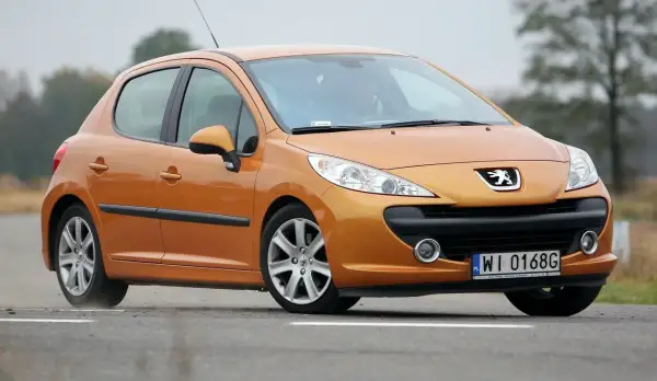 Pomarańczowy Peugeot 207 1.6 HDi na drodze.