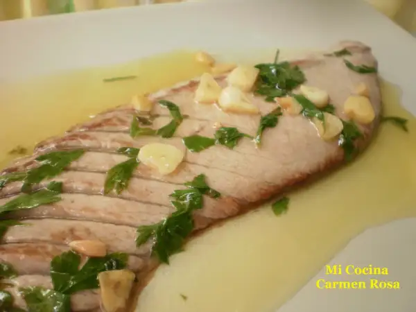 Deliciosa ventresca a la plancha con ajo laminado y perejil fresco, nadando en un sabroso aceite.