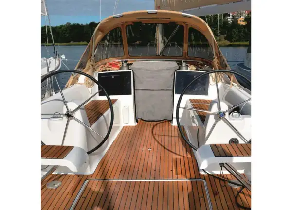 Il ponte di uno yacht con due timoni, un tendalino e un boccaporto, pronto per la navigazione.