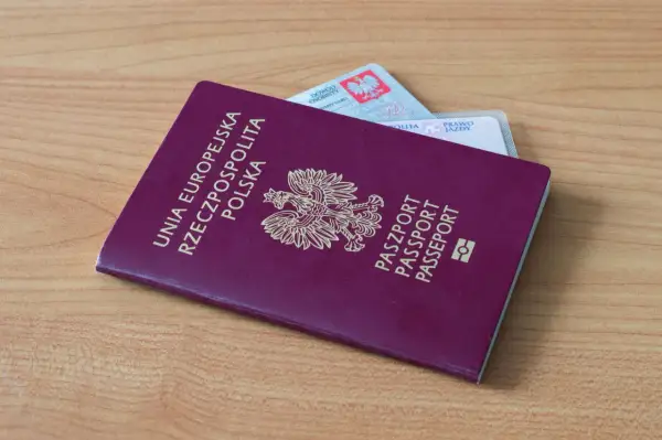 Polski paszport i dowód osobisty leżą na drewnianym stole. Czy na Wyspy Kanaryjskie potrzebny jest paszport? Tak, jeśli nie podróżujesz na dowód.