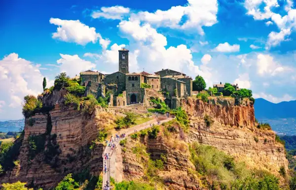 Antico centro storico su una rupe, con un ponte pedonale che conduce al borgo.