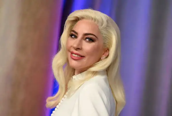 Lady Gaga med blont hår och vit klänning, ser ut som en stjärna som kan ha barn.