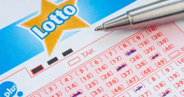 Kupon Lotto z zaznaczonymi liczbami, gotowy do gry w multi systemy na 3 liczby. Długopis czeka na kolejne wybory.