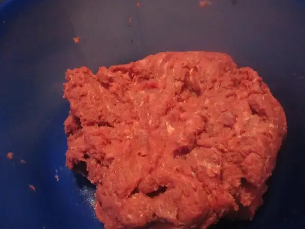Frisches Hackfleisch, frisch gewolft, bereit für die Zubereitung von Frikadellen. Das gewolft bedeutungsvolle Fleisch liegt in einer blauen Schüssel.