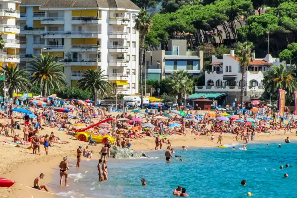 Lloret de Mar pogoda kwiecień: plaża pełna ludzi, słońce, palmy i turkusowe morze. Idealny dzień na wypoczynek.