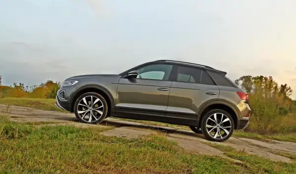 Szary VW T-Roc na tle jesiennego krajobrazu. Poznaj jego wymiary i możliwości terenowe.
