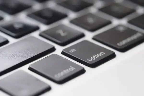 Zbliżenie na klawiaturę laptopa, widoczne klawisze "control", "alt", "option" i "command". Klawisz spacji jest pusty.