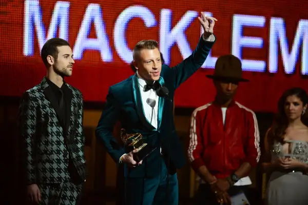 Macklemore odbiera nagrodę Grammy: najlepszy debiutujący artysta. Obok niego stoją Lewis Hamilton, Pharrell Williams i Anna Kendrick.