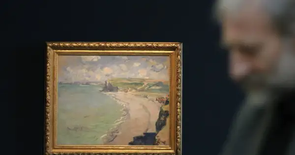Obraz przedstawia malowniczą plażę w Pourville, z klifami i morzem w tle.