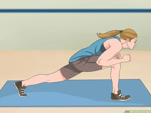 Woman performing a dynamic jumping lunges exercise on a blue mat, demonstrating proper form for an explosive workout.