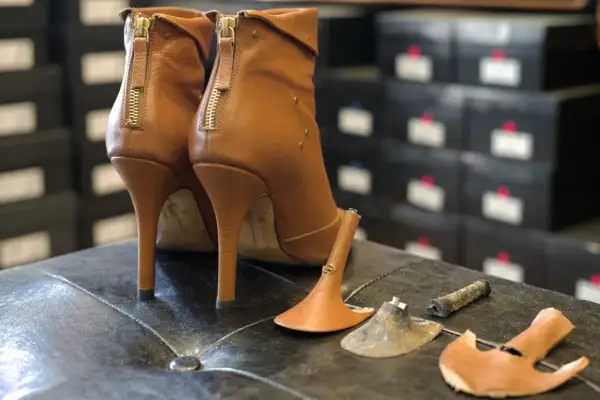 Bottes à talons aiguilles marron avec talons cassés, prêtes à réparer chaussures.