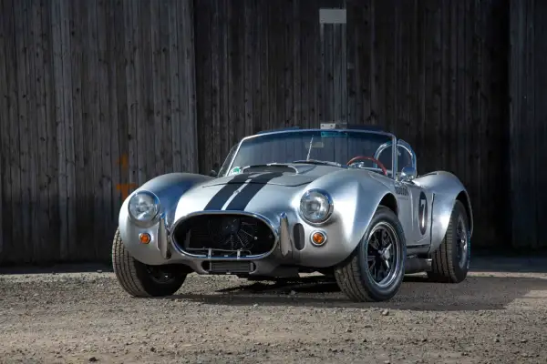 Silberner Cobra Shelby mit schwarzen Streifen, bereit für die Rennstrecke.