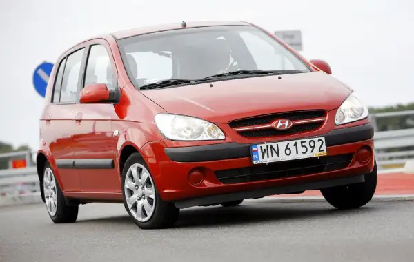 Czerwony Hyundai Getz 1.1 z polskimi tablicami WN 61592 na drodze.
