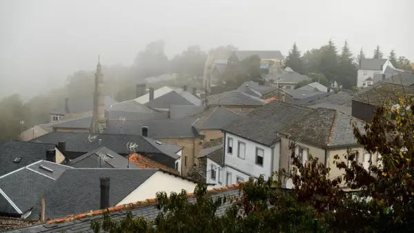Tejado de pizarra en un pueblo de Manzaneda, Galicia, envuelto en niebla.