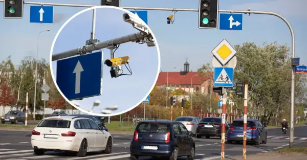 Kamery na skrzyżowaniach rejestrują wykroczenia. Widok na ruchliwe skrzyżowanie z sygnalizacją świetlną i znakami drogowymi.