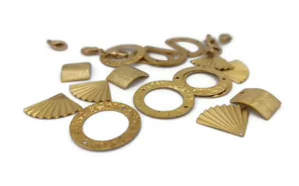 Diverses breloques en laiton aux formes variées : éventails, carrés, cercles texturés. Idéal pour la création de bijoux, leur laiton utilisation est multiple.
