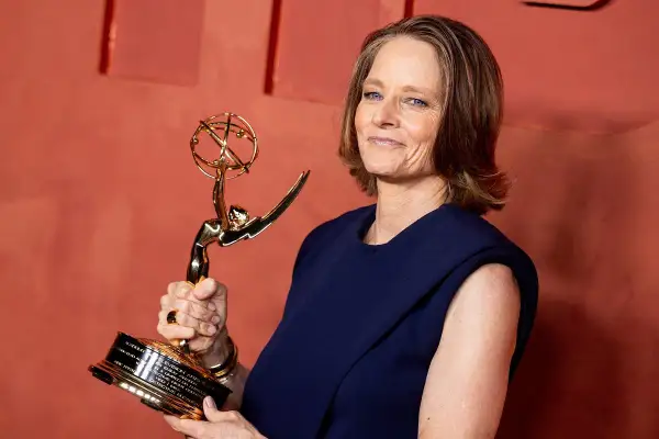 Jodie Foster z dumą trzyma swoją nagrodę Emmy, błyszczącą statuetkę symbolizującą jej wybitne osiągnięcia w telewizji.